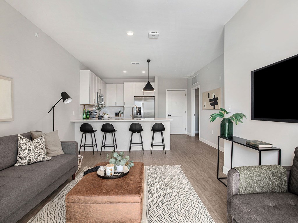 a living area with a couch coffee table and a tv  at Signature at West Pryor, Lee's Summit, Missouri