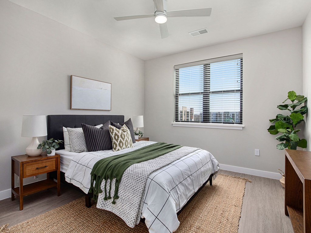 a bedroom with a large bed and a ceiling fan  at Signature at West Pryor, Missouri, 64081