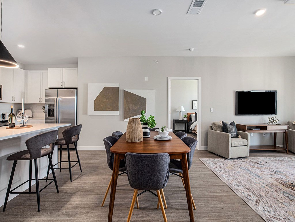 a living room and kitchen area with a dining table and chairs  at Signature at West Pryor, Missouri, 64081