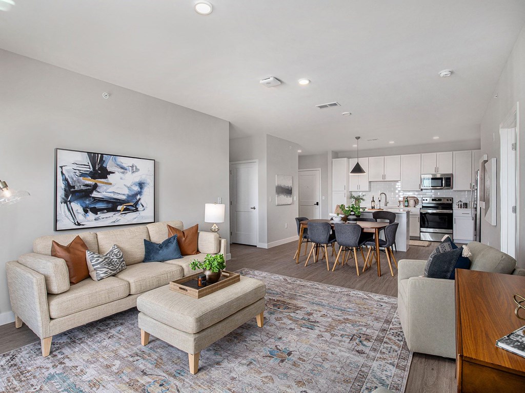 a living room and dining room with a kitchen in the background  at Signature at West Pryor, Missouri, 64081