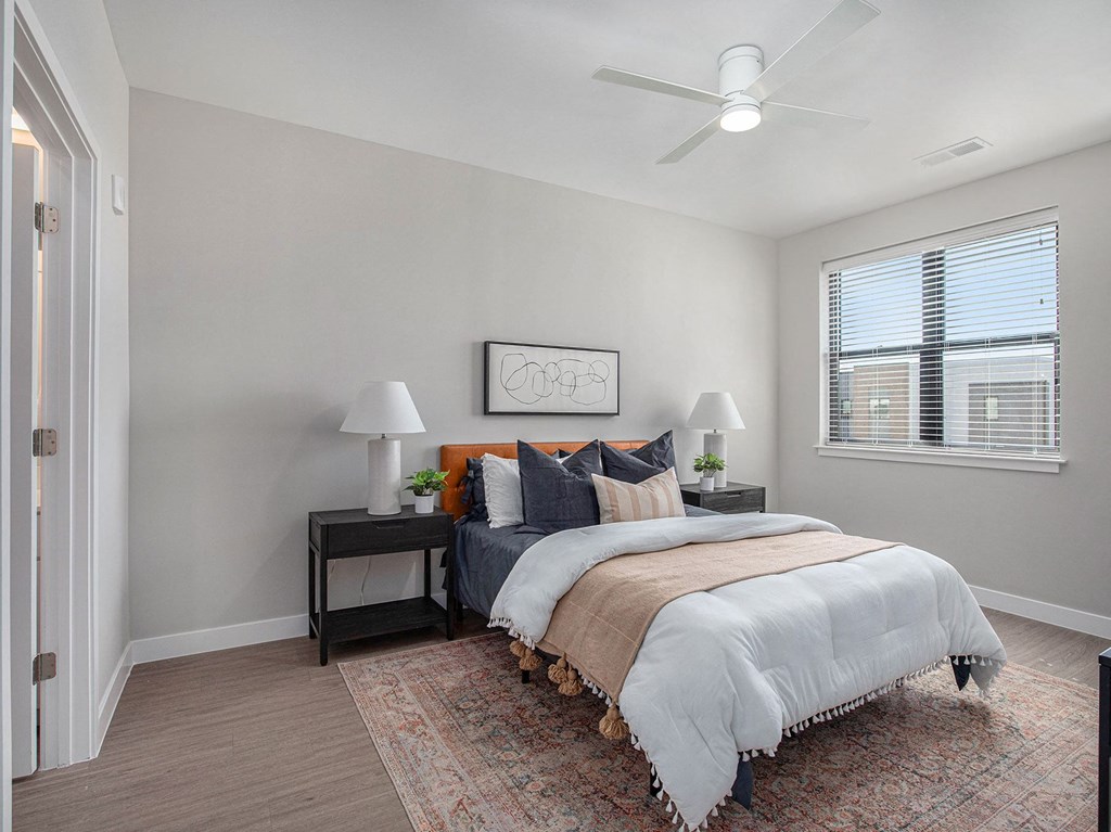a bedroom with a large bed and a ceiling fan  at Signature at West Pryor, Lee's Summit, Missouri