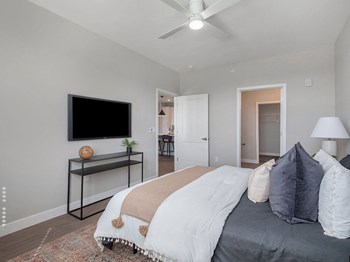 a bedroom with a large bed and a ceiling fan - Photo Gallery 6