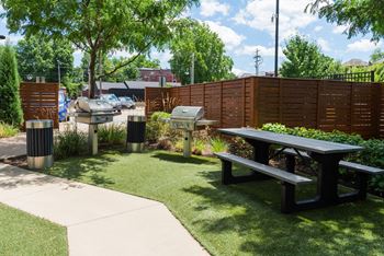 A park with a picnic table and a fence.