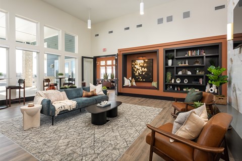 A living room with a blue couch and a brown chair at Montage at Hawk Ridge Apartments, Lake St. Louis