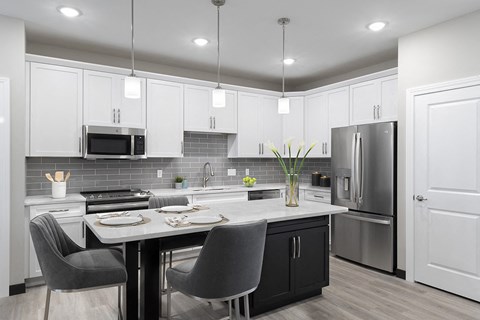 A modern kitchen with a dining table and chairs.