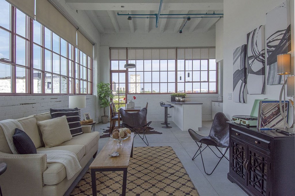 a living room with a couch and chairs and a desk