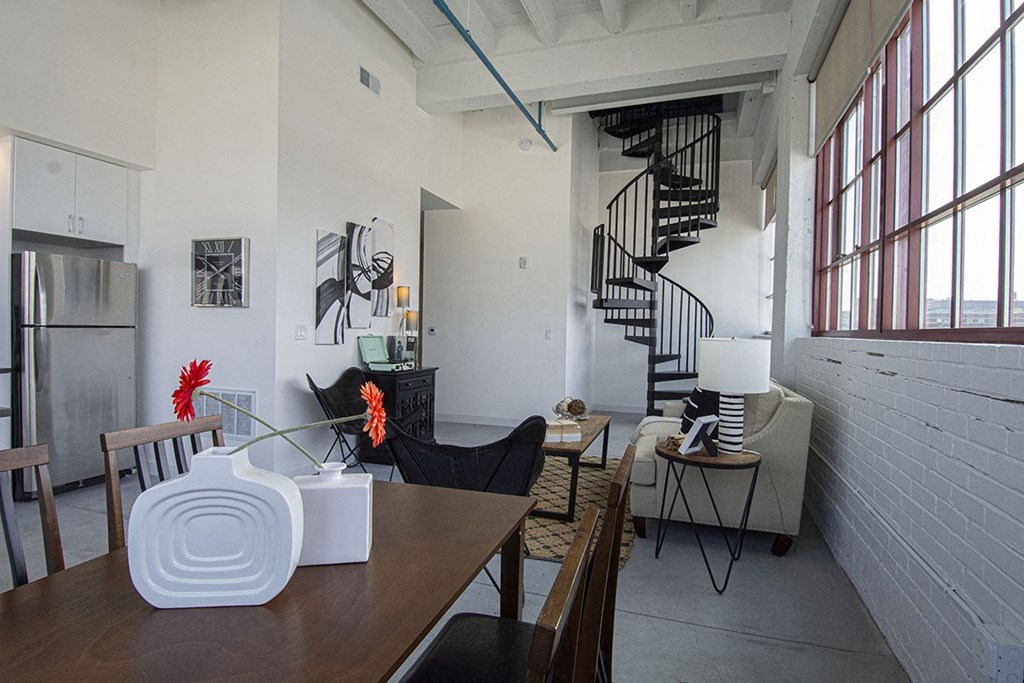 the living room and dining area of a loft apartment