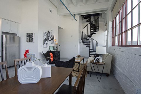the living room and dining area of a loft apartment