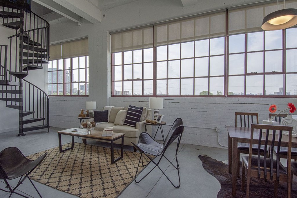 a living room with a couch and a table and a spiral staircase