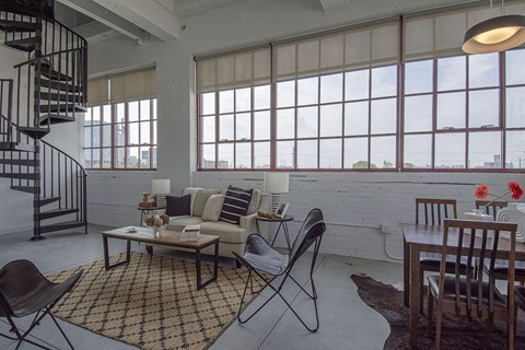 a living room with a couch and a table and a spiral staircase