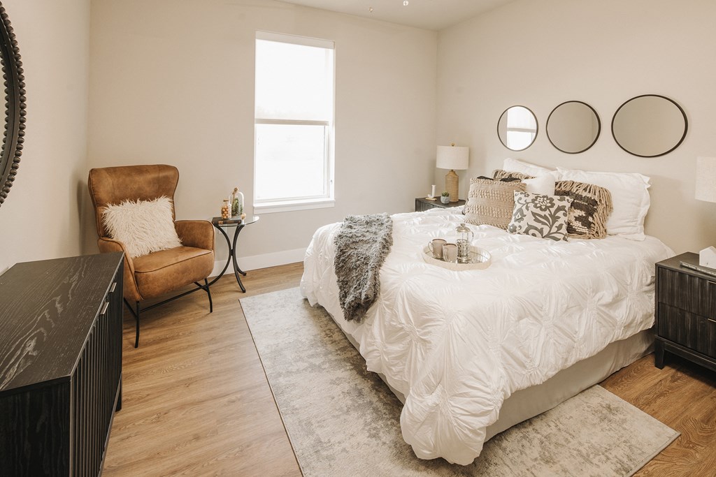 a bedroom with a bed and a chair and a window at 44 West Luxury Living, Valley Park, Missouri