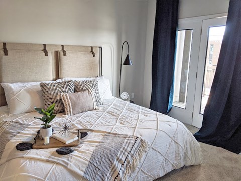 Cozy bedroom with upholstered headboard and bedding at GrandView Flats and Townhomes Apartments, Granger, IN 46530