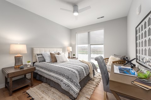 a bedroom with a large bed and a window at The Flats & Terraces at Wildhorse Village, Missouri, 63005
