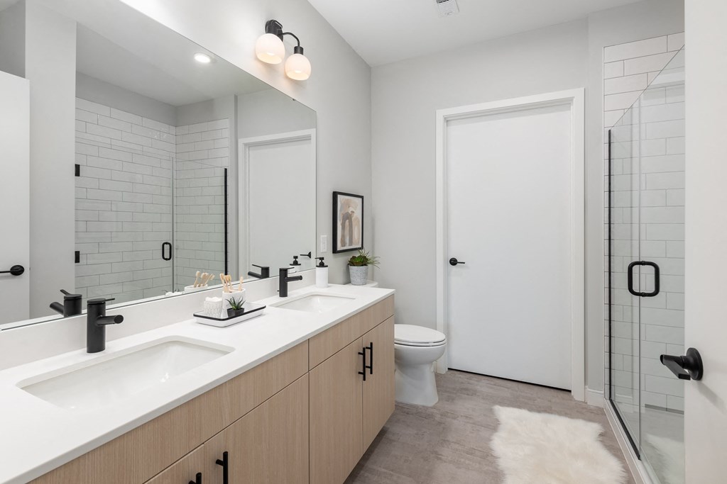 a bathroom with two sinks and a shower and a toilet
