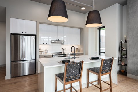 a kitchen with a large island and two chairs