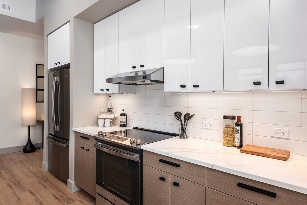 a kitchen with white cabinets and a stove and a refrigerator at Bemiston Place Apartments, Clayton Missouri