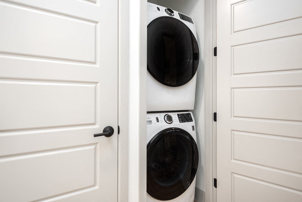 a washer and dryer in a closet with white doors at Bemiston Place Apartments, Clayton