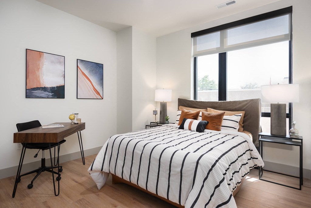 a bedroom with a bed and a large window at Bemiston Place Apartments, Missouri