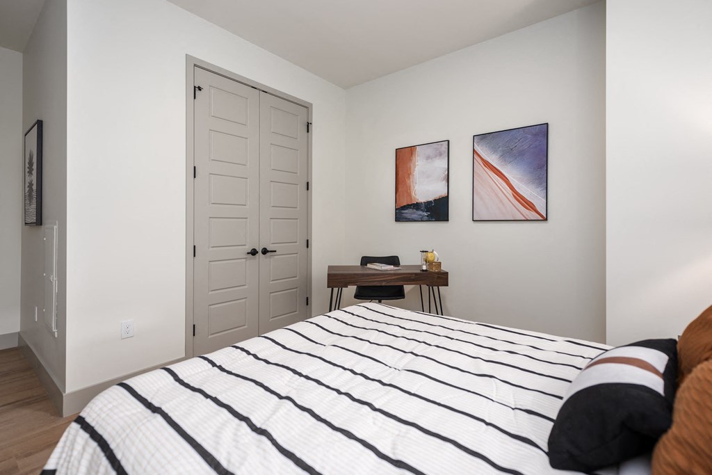 a bedroom with a bed and two paintings on the wall at Bemiston Place Apartments, Clayton Missouri