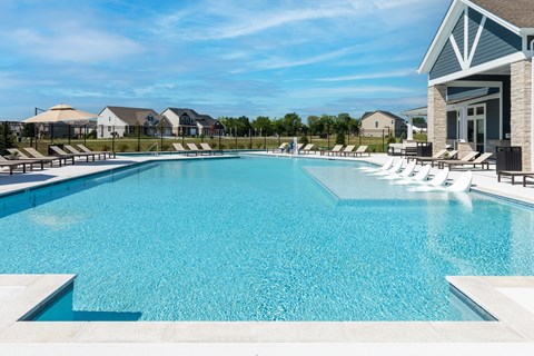 A large swimming pool with a building on the right side.