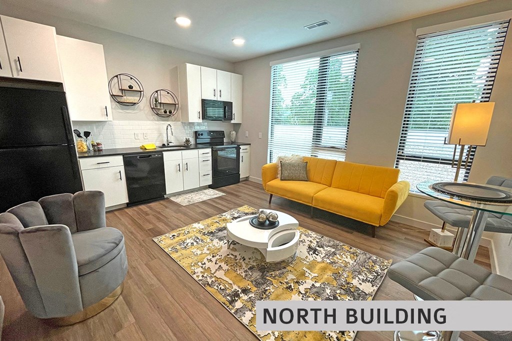 a living room with a yellow couch and a kitchen in the background  at Expo at Forest Park, St. Louis, MO, 63112