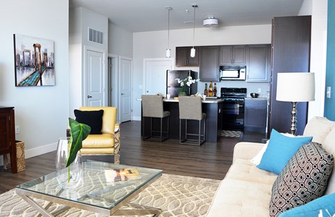 A modern living room with a glass coffee table and a white sofa.