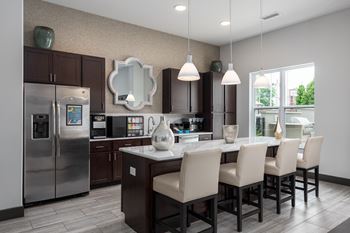 A modern kitchen with a large island and chairs.