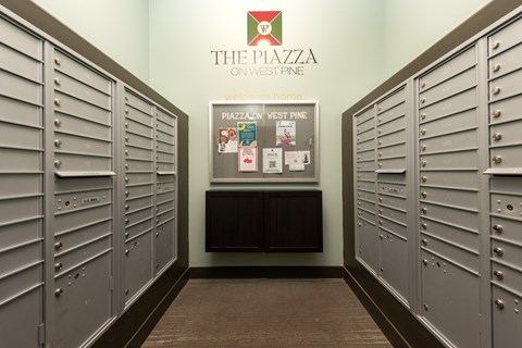 A hallway with lockers and a sign that says The Piazza on West Pine.