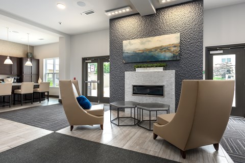 A modern living room with a fireplace and two chairs.