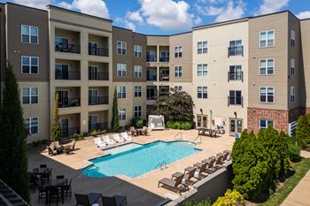 A large apartment complex with a pool in the courtyard.