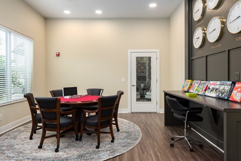 A conference room with a table and chairs and a wall of clocks.