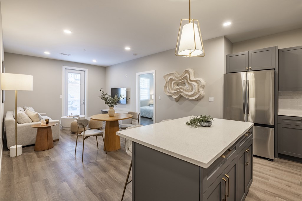 A modern kitchen with a white island and stainless steel appliances.at Preserve at Sycamore Creek, Osage Beach, MO 65065