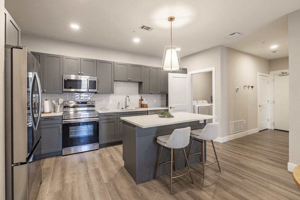 A modern kitchen with a large island and stainless steel appliances.at Preserve at Sycamore Creek, Osage Beach, MO