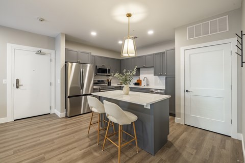A kitchen with a table and chairs in the middle.