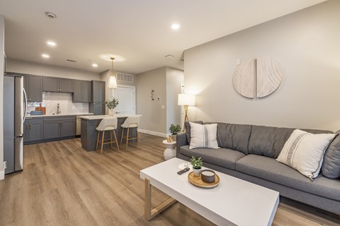 A modern living room with a grey couch and a white coffee table.