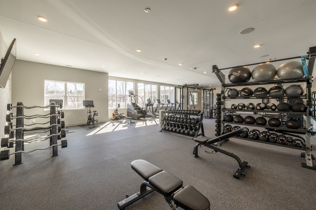 A spacious gym with a variety of equipment including weights and machines.at Preserve at Sycamore Creek, Missouri