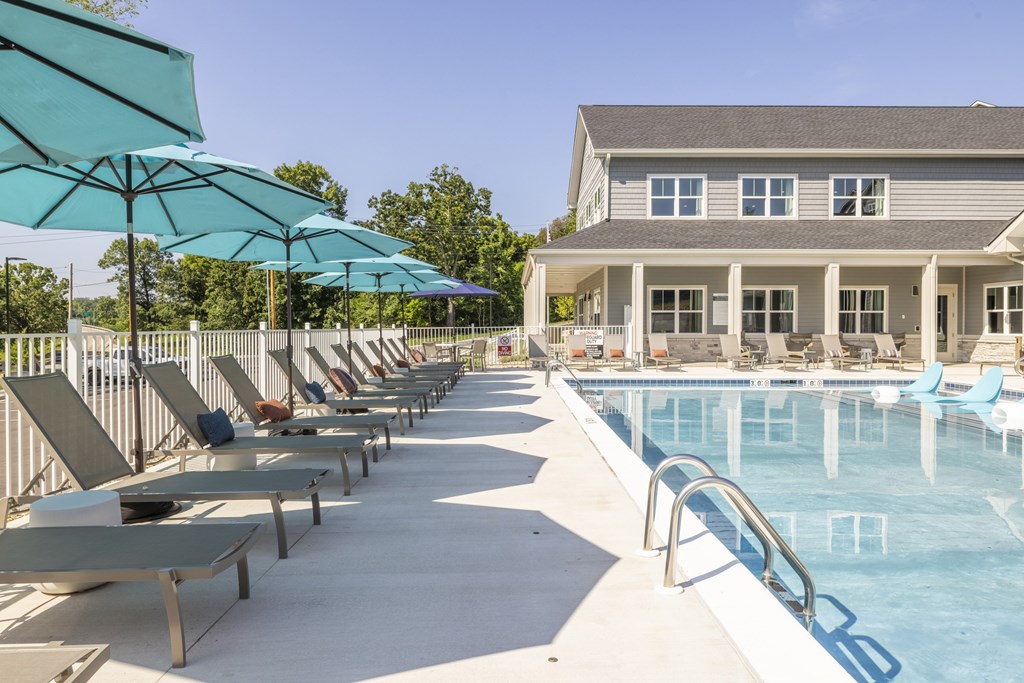 A pool area with sun loungers and umbrellas.at Preserve at Sycamore Creek, Missouri 65065