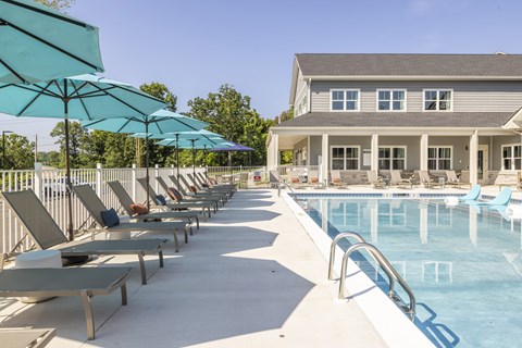 A pool area with sun loungers and umbrellas.at Preserve at Sycamore Creek, Missouri 65065