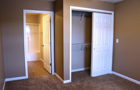 a bedroom with a closet and an open closet door