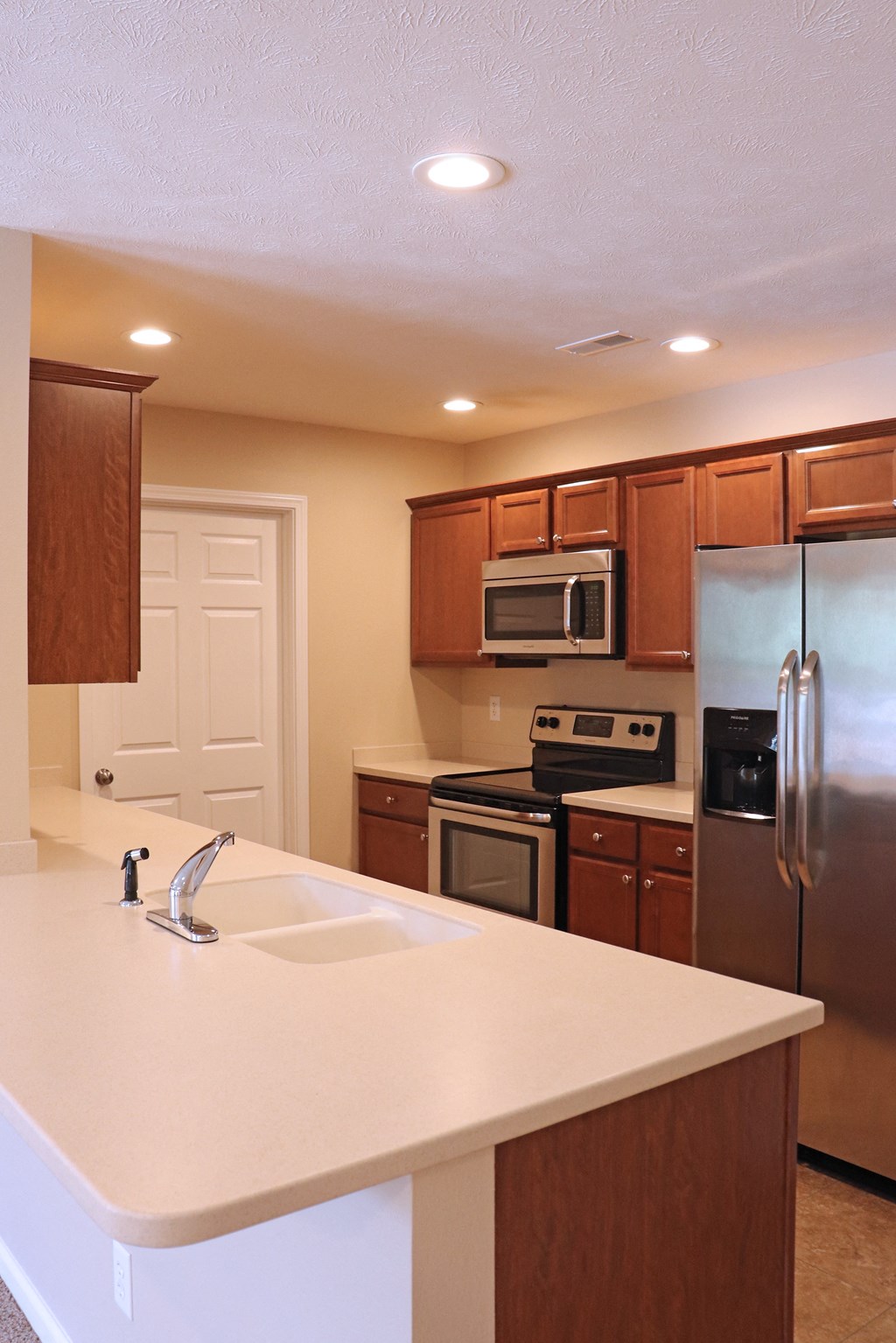 Kitchen with oak cabinets and white countertops
