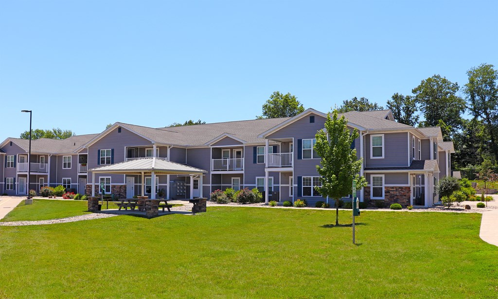 Grassy area with gazebo and buildings in the background