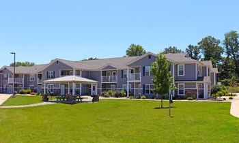 Grassy area with gazebo and buildings in the background - Photo Gallery 6