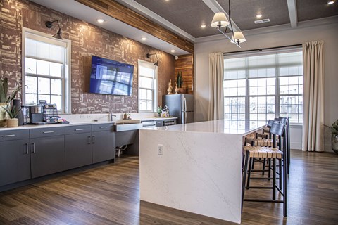 a kitchen with a large white island and a bar with chairs