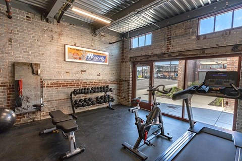 the gym has plenty of equipment and a window to the street