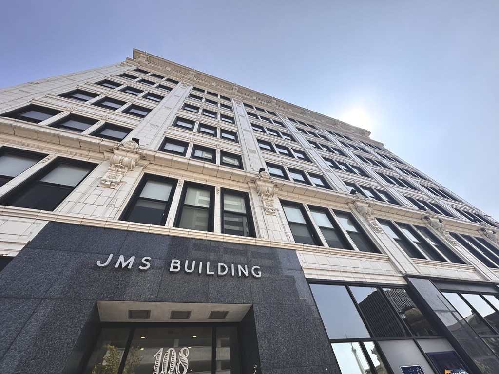 The JMS Building is a tall, gray structure with many windows.