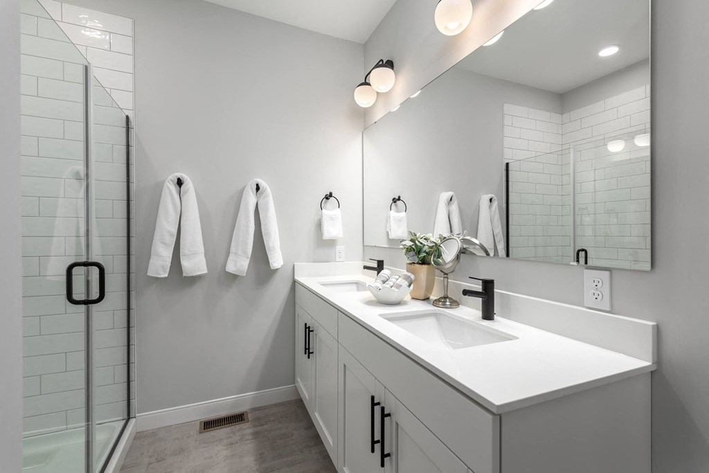 a white bathroom with a sink and a shower