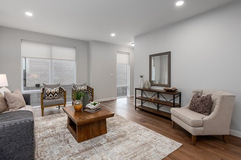 a living room with a couch and a coffee table at The Flats & Terraces at Wildhorse Village, Chesterfield, MO
