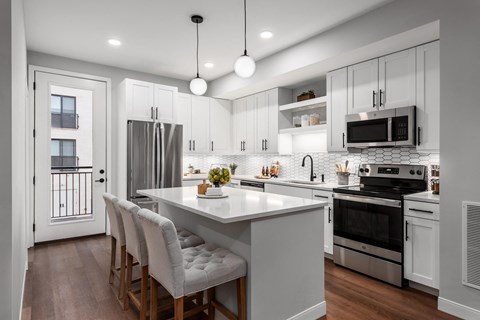 A modern kitchen with a large island and stainless steel appliances.