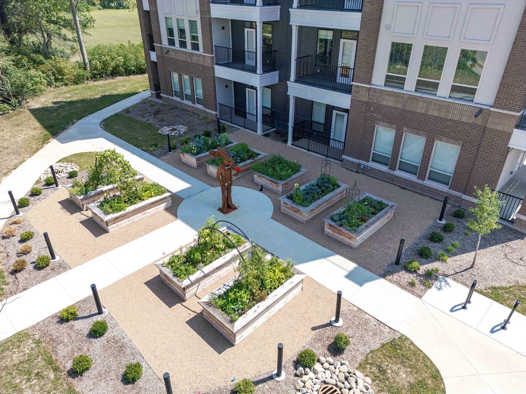 A courtyard with a fountain and planters in front of a building.