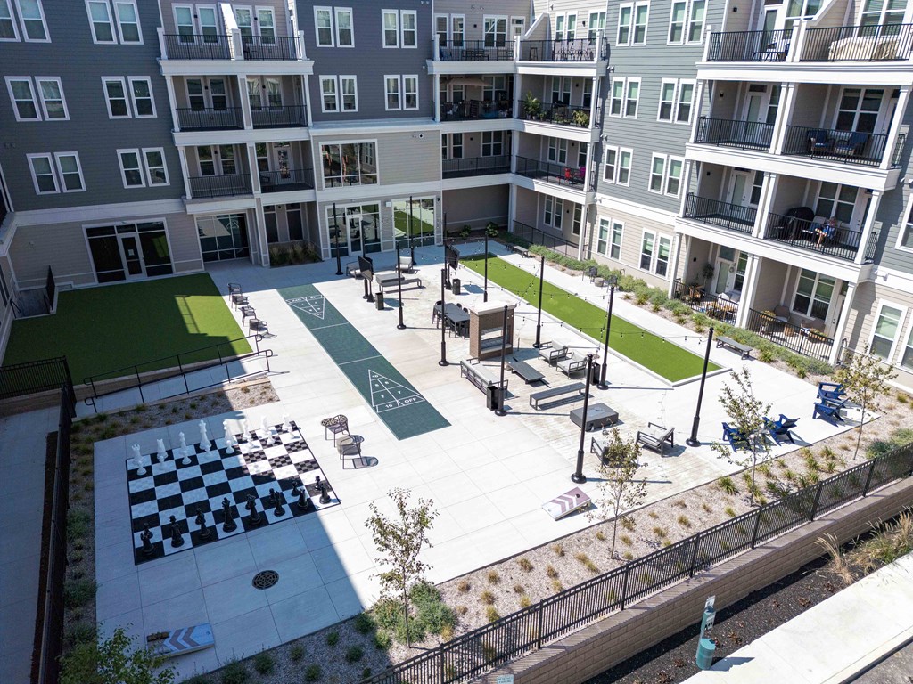 A courtyard with a chess board and chairs.